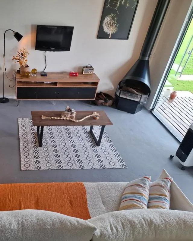 A sala com sofá, TV e a lareira
